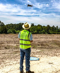 Remote Pilot In Charge operating a Mavic 2 Pro over a field and 90 acreas